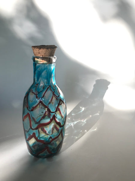 copper ruby / copper blue with red luster netted port bottle