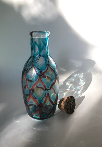 copper ruby / copper blue with red luster netted port bottle